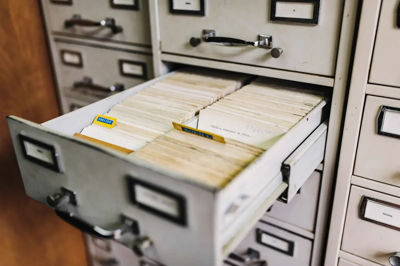 An open filing cabinet drawer full of index cards with labeled tabs