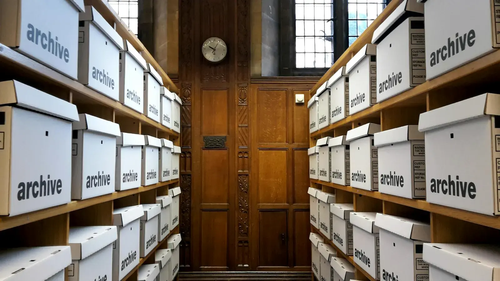 An aisle of shelves lined with labeled archive boxes