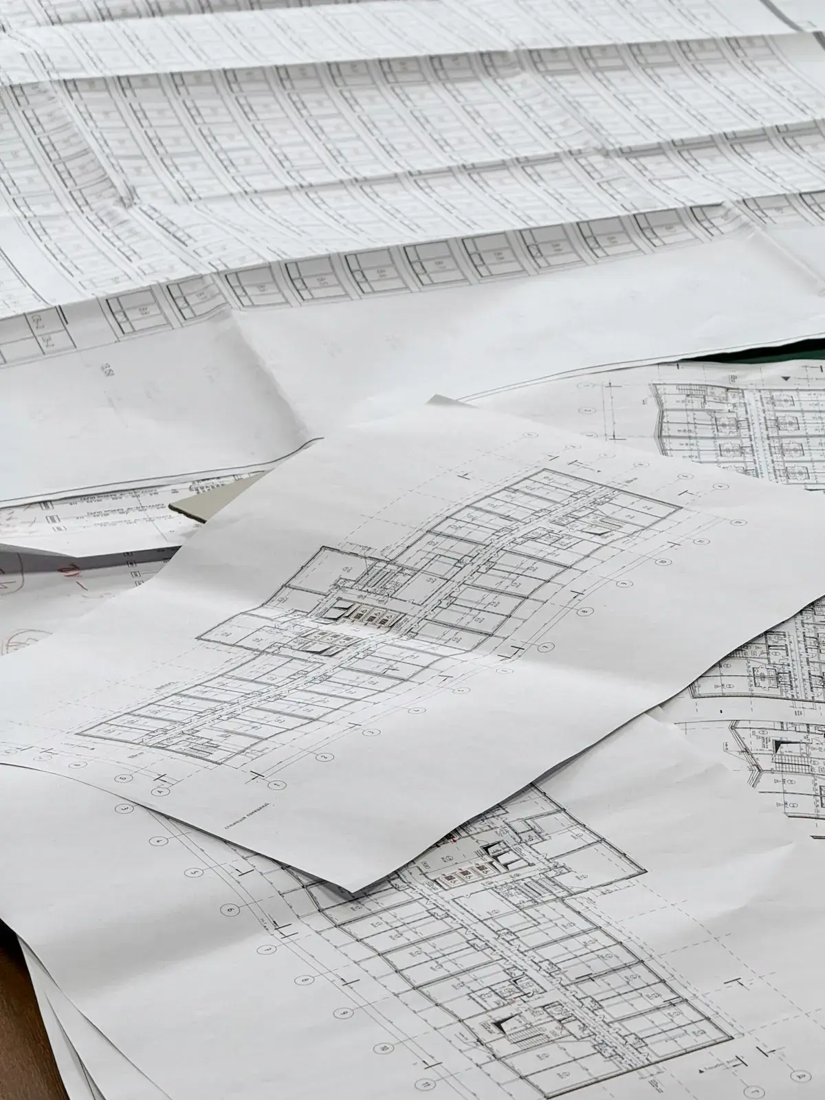 Architectural floor plans and construction drawings spread across a table
